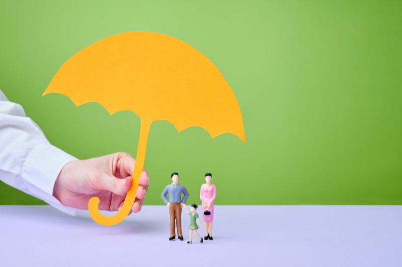 An umbrella is covering the family of four members